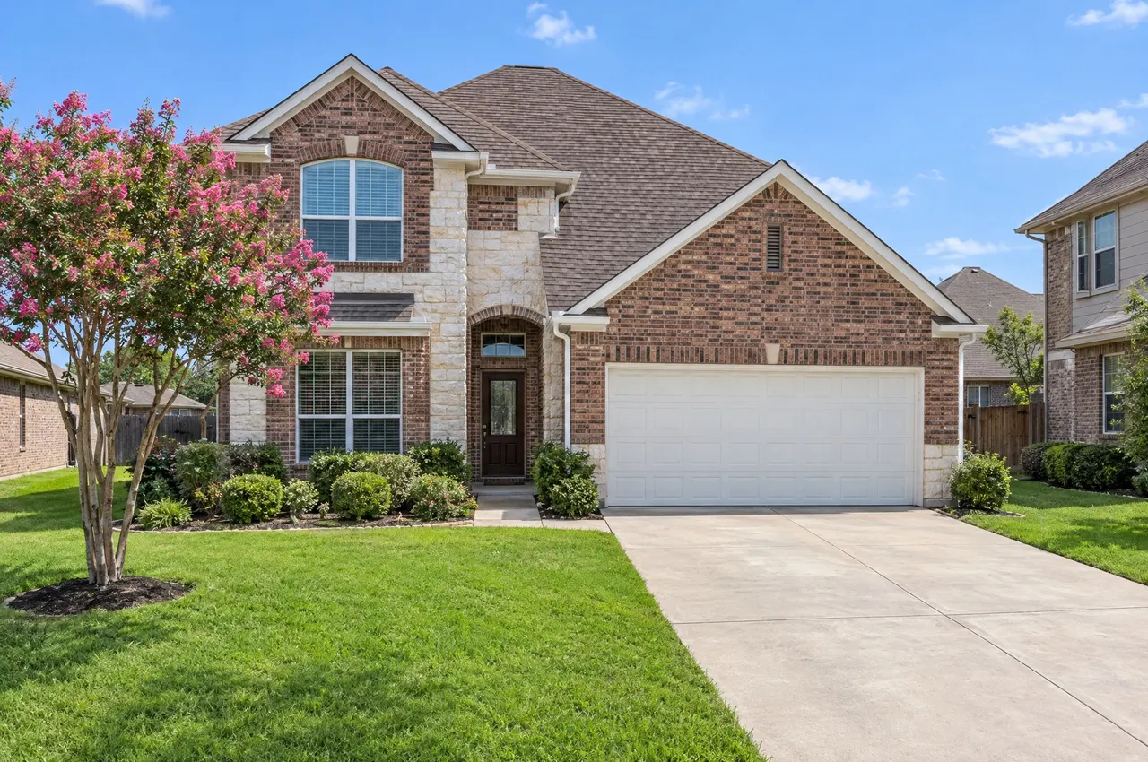Two-story brick and stone home in a Round Rock subdivision with a new architectural shingle roof